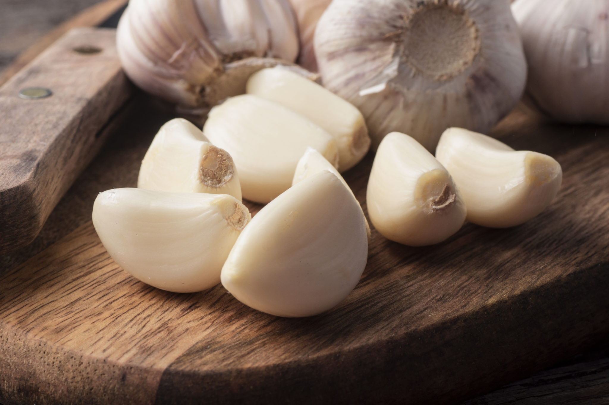 Sliced garlic on wood background.